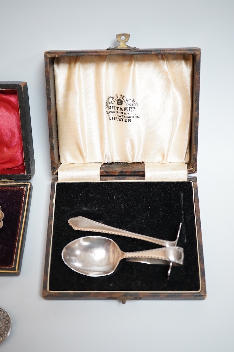 A cased pair of late Victorian silver shell salts on ball feet, with matching spoons, H. Bros, Birmingham, 1895, 46mm, together with a cased George V silver spoons and pusher and a Victorian silver shoe buckle (a.f.)